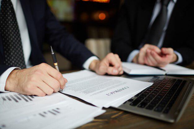 A person signing documents for a bilingual criminal defense attorney in Tijuana, Mexico