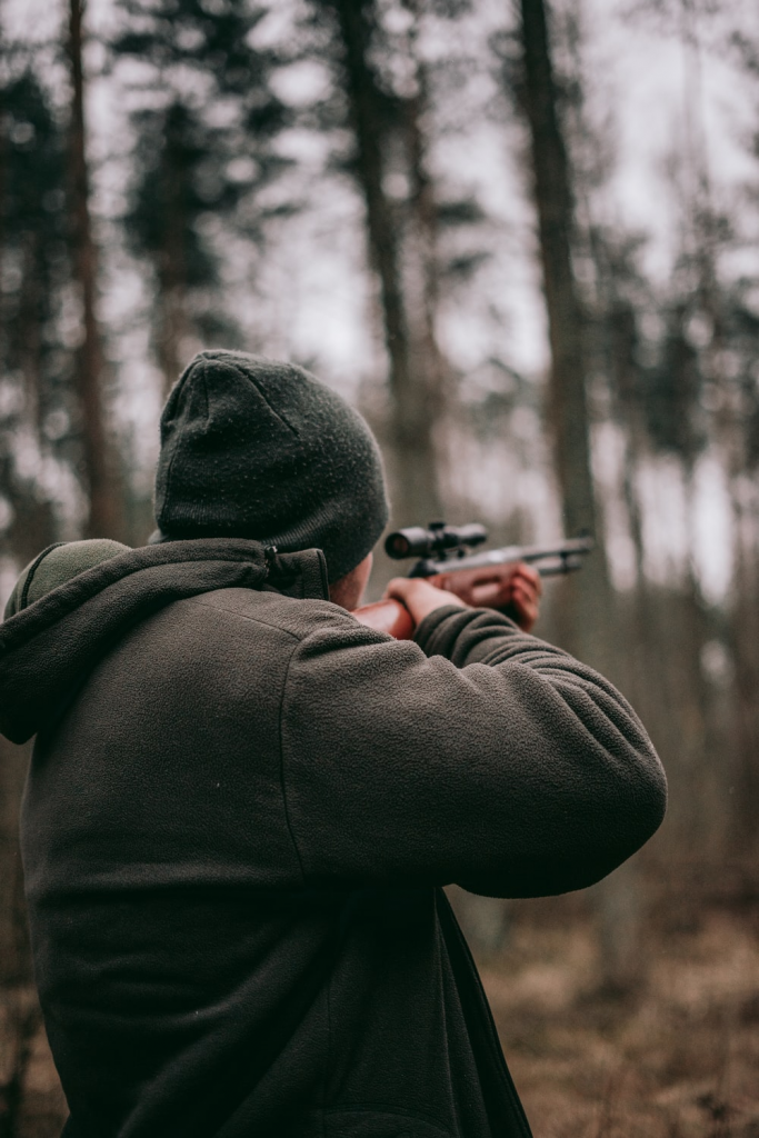  A person aiming a scoped rifle