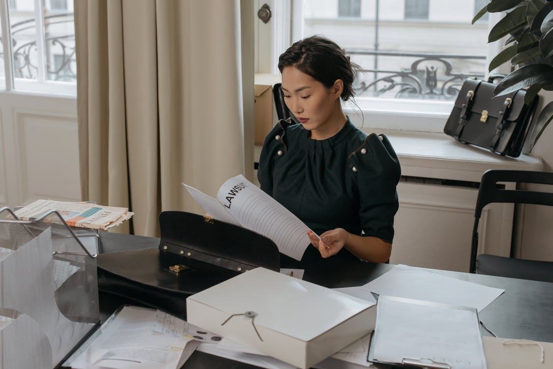 A woman going through lawsuit documents in an office